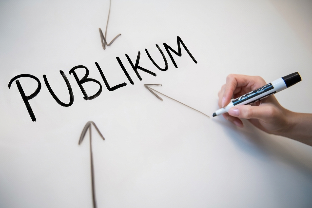 Na tabuli je napsáno slovo „publikum" se šipkami mířícími k němu