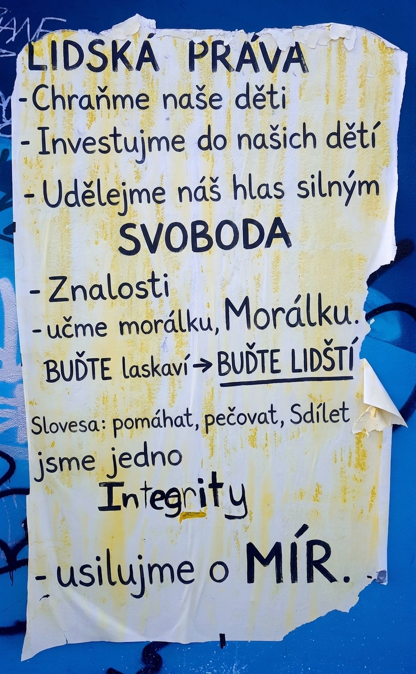Fotografie roztrhnutého plakátu na zdi s etickými prohlášeními.