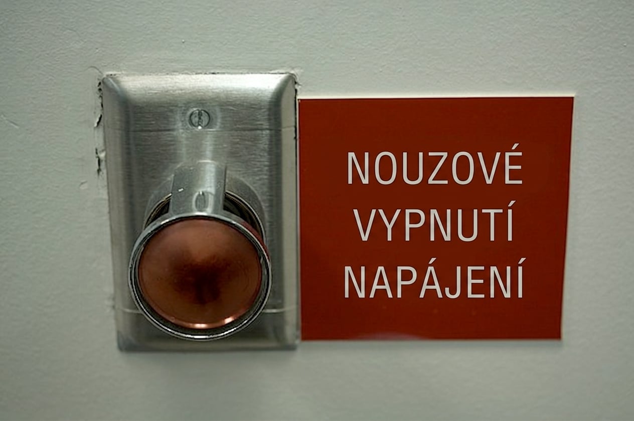 Velké červené tlačítko s nápisem „Emergency power off" vedle něj