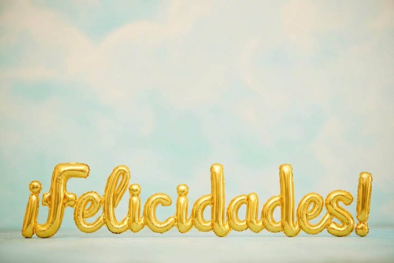 globos dorados en un cielo azul que dicen “congrats”