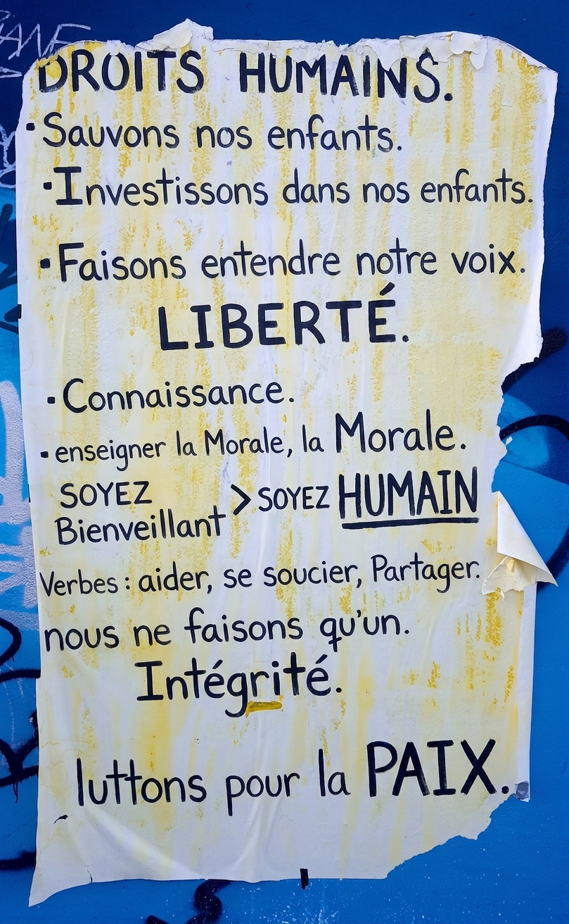 Photo d'une affiche déchirée sur un mur avec des déclarations éthiques.