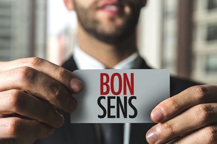Homme tenant une étiquette sur laquelle est écrit « common sense »