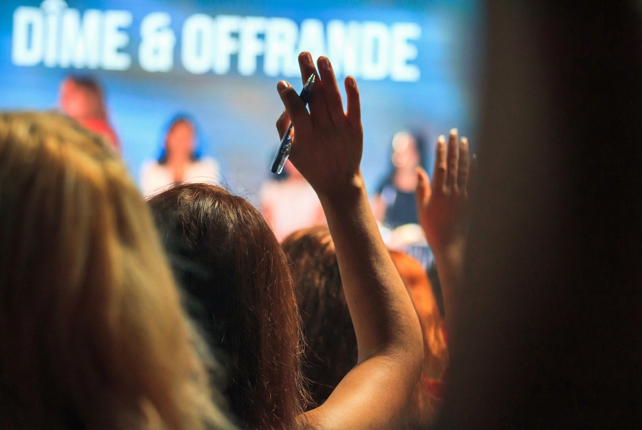 Image d'une personne dans le public levant la main pour poser une question au panel