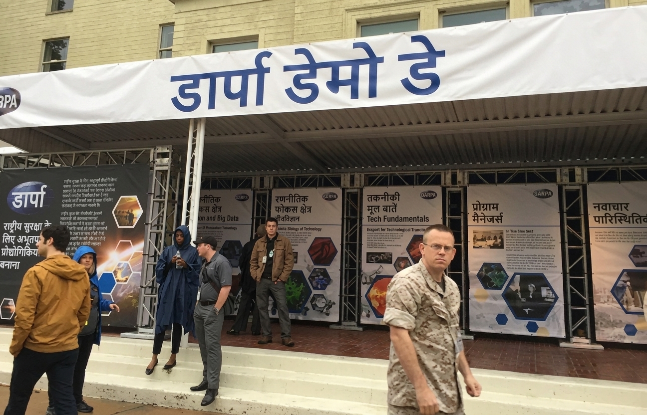 कॉन्फ्रेंस एग्ज़िबिशन बूथों की छवि, ऊपर बैनर पर "DARPA Demo Day" लिखा है