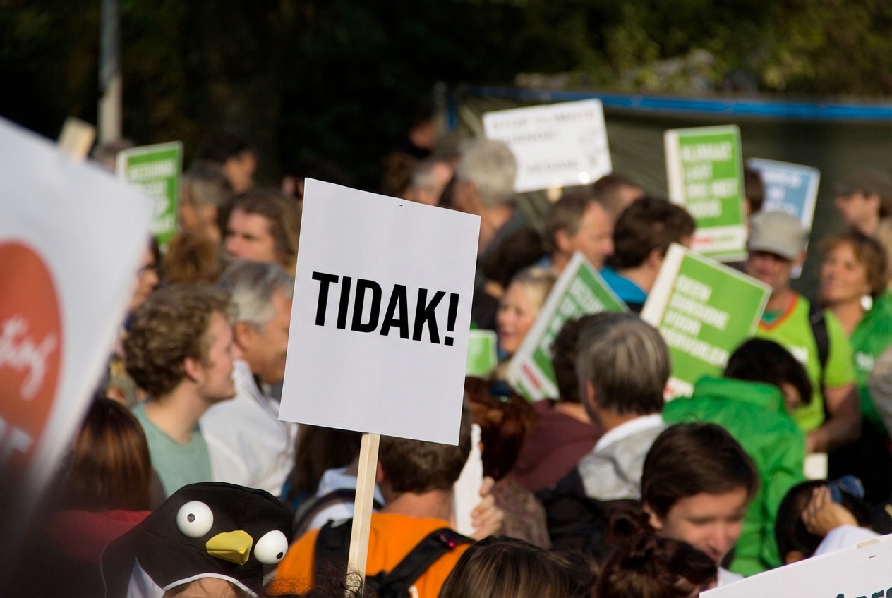 Sebuah protes dengan seorang demonstran memegang papan bertuliskan “Tidak!”