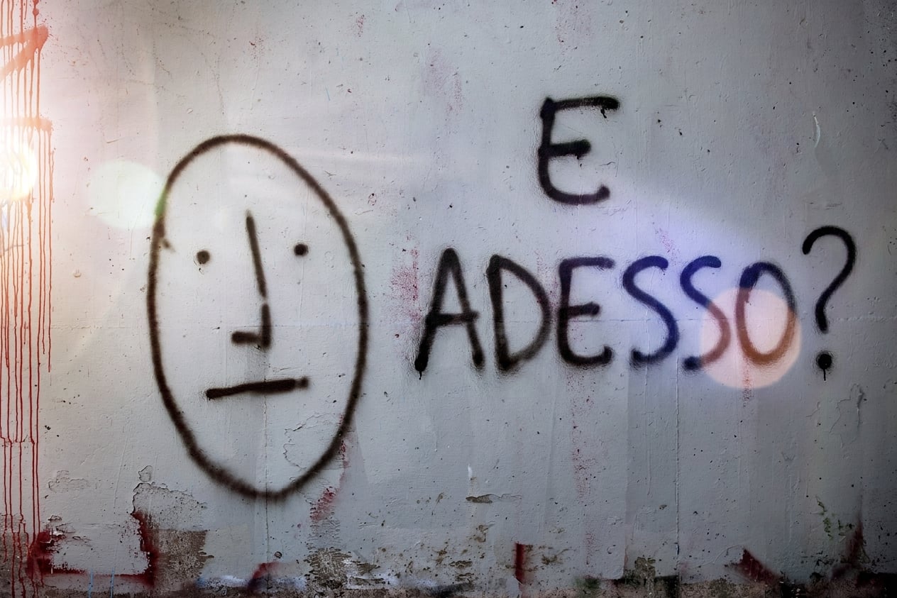 graffiti su un muro che chiedono e adesso.jpg
