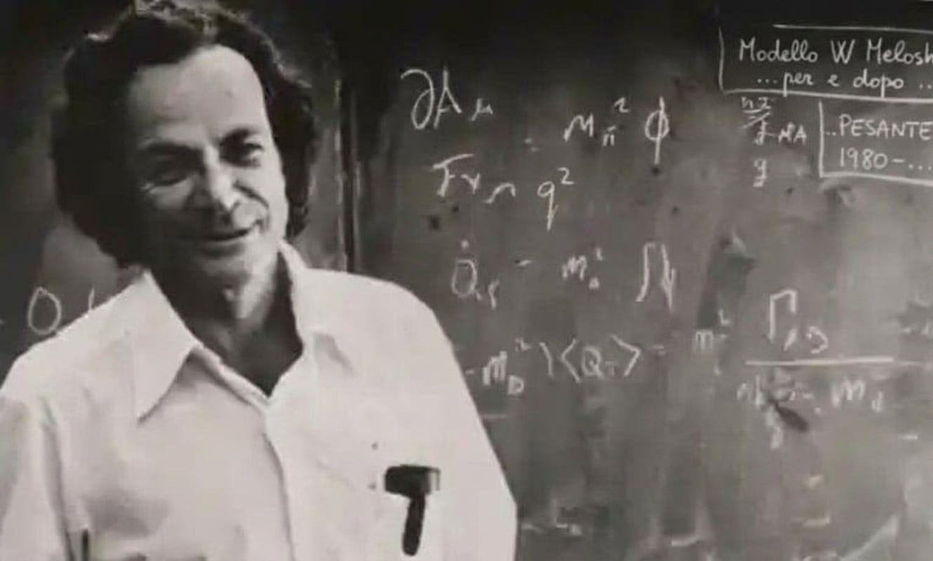 Richard Feynman davanti a una lavagna con equazioni