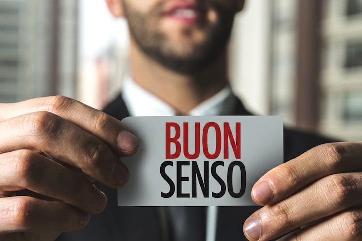 Uomo che tiene un cartellino con su scritto "common sense"