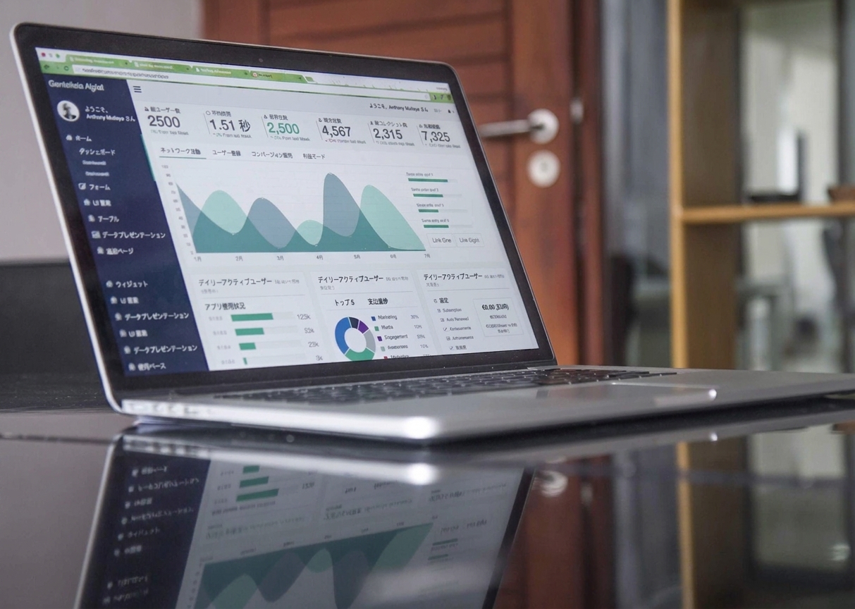 KPI とグラフを表示したダッシュボードが映るノートパソコン