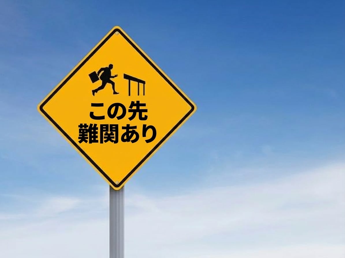 「この先課題」と書かれ、ハードルを跳ぶ人の道路標識