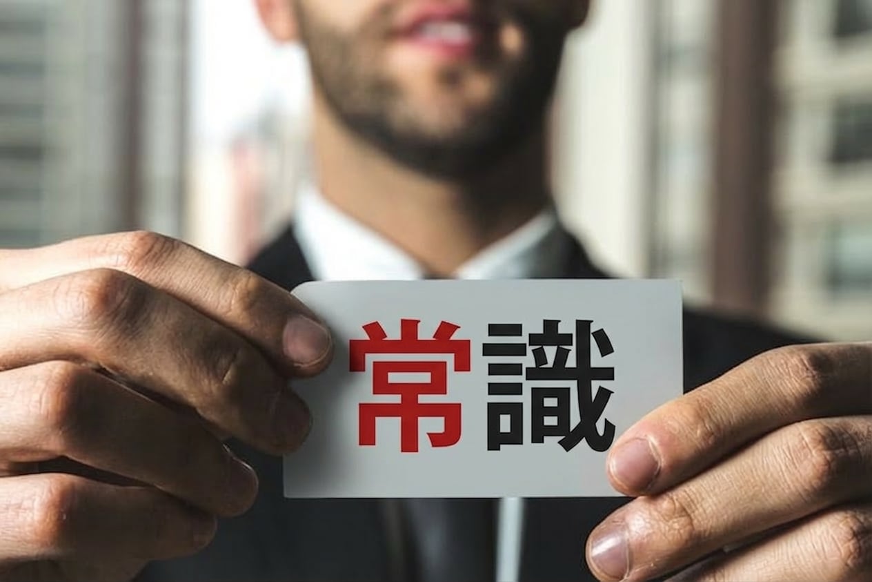 「常識」と書かれたラベルを掲げる男性