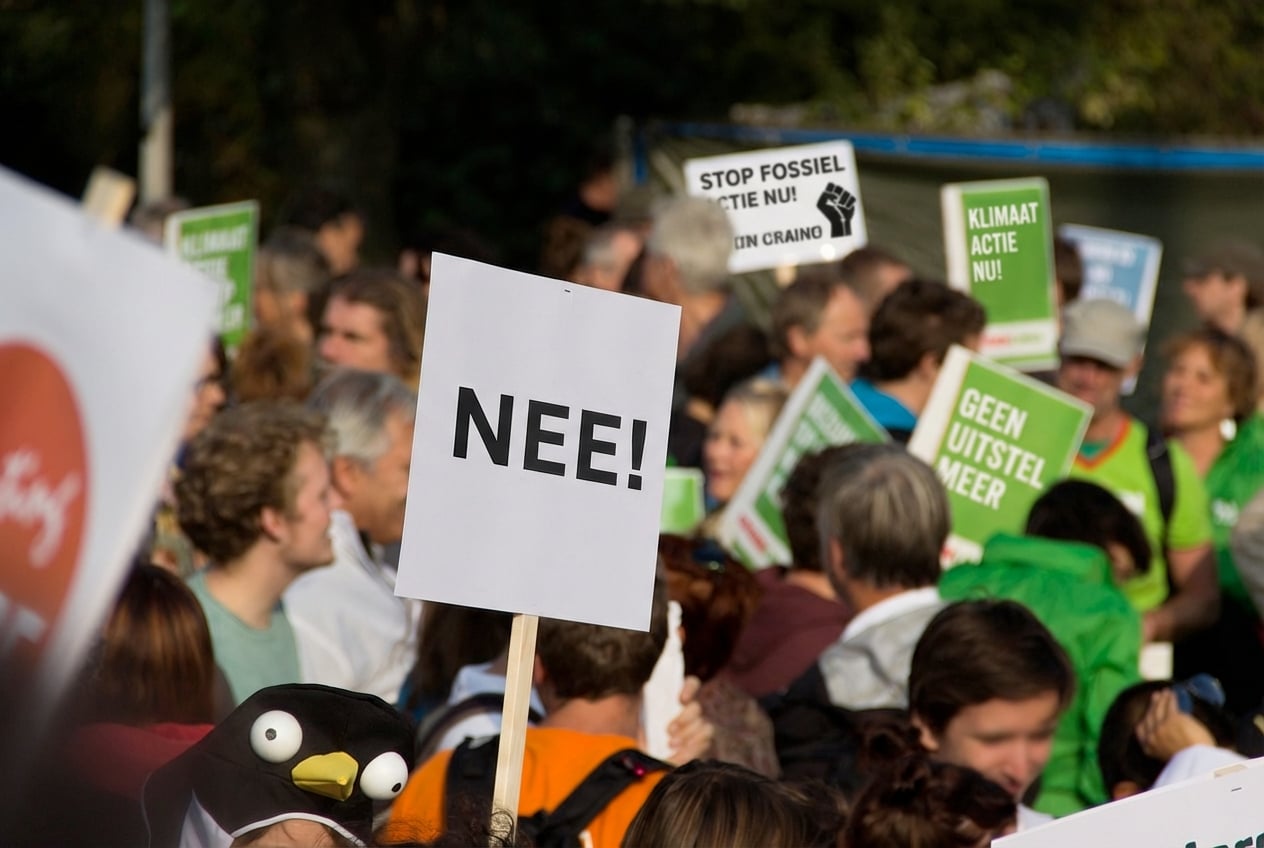 Een protest met een demonstrant met een bord met “No!”