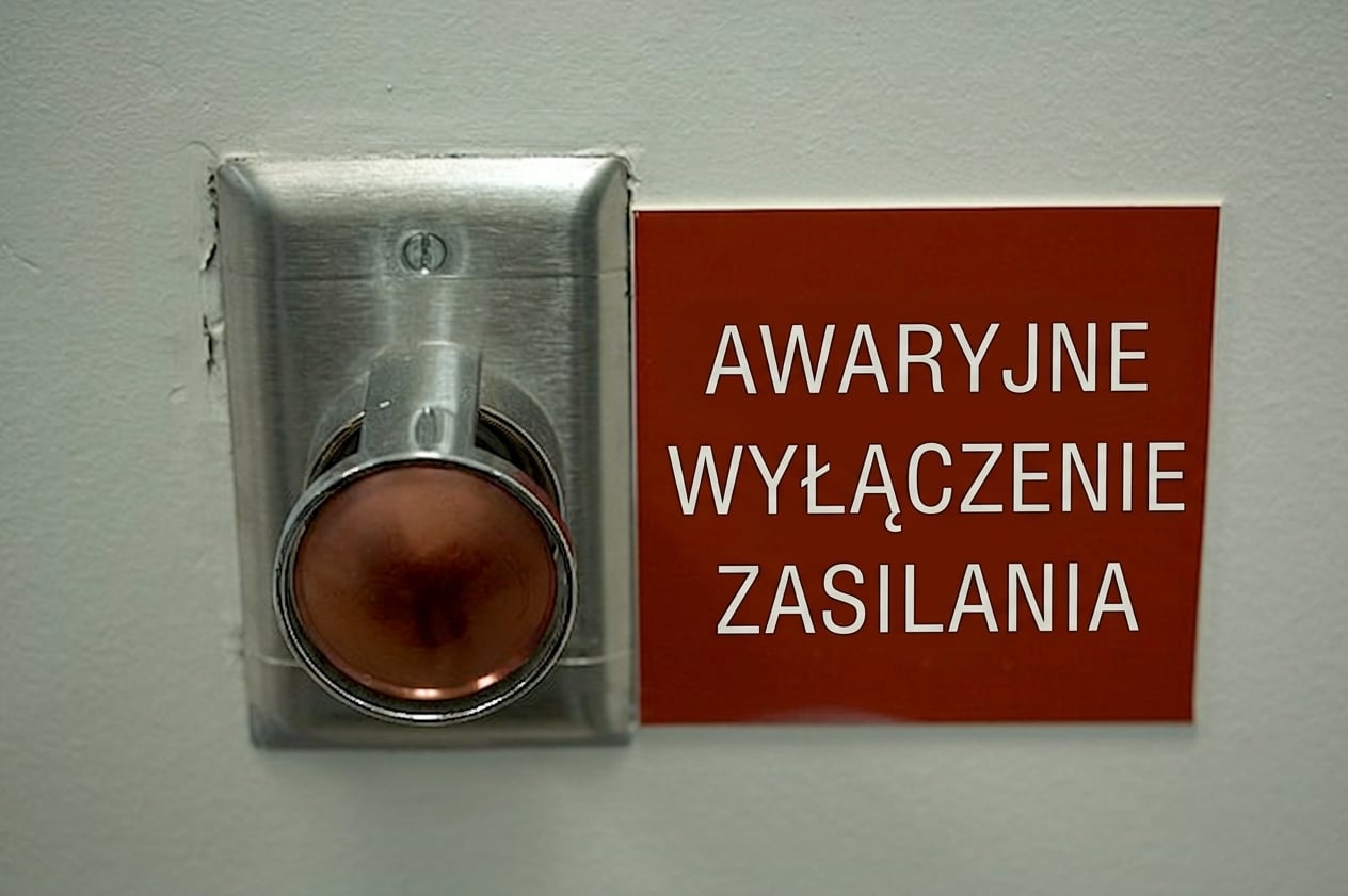 Obraz dużego czerwonego przycisku z tabliczką „Emergency power off" obok