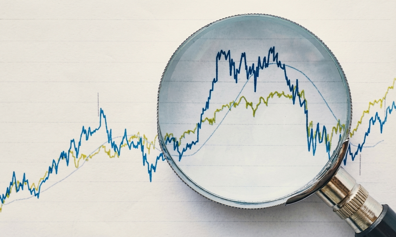 Uma lupa sobre gráficos, representando revisão financeira