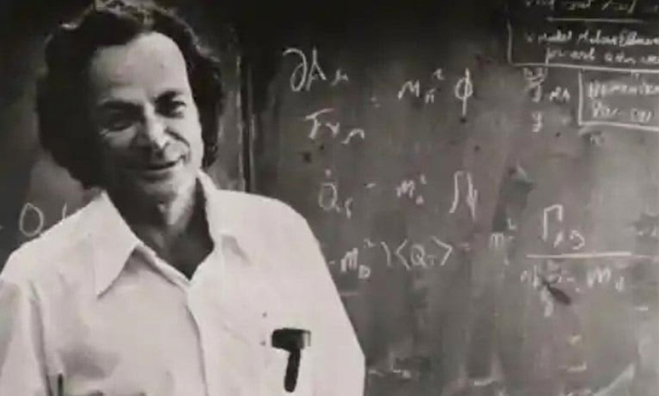 Richard Feynman stă în fața unei table cu ecuații matematice