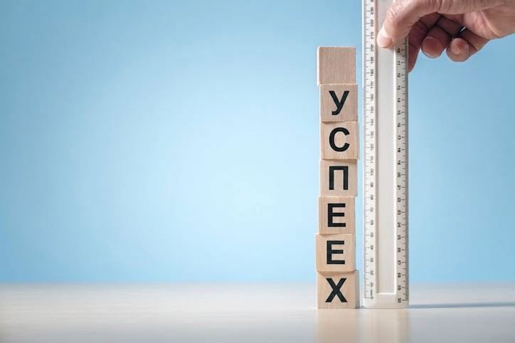 Линейка, приложенная к блокам со словом «успех», иллюстрирует измерение прогресса