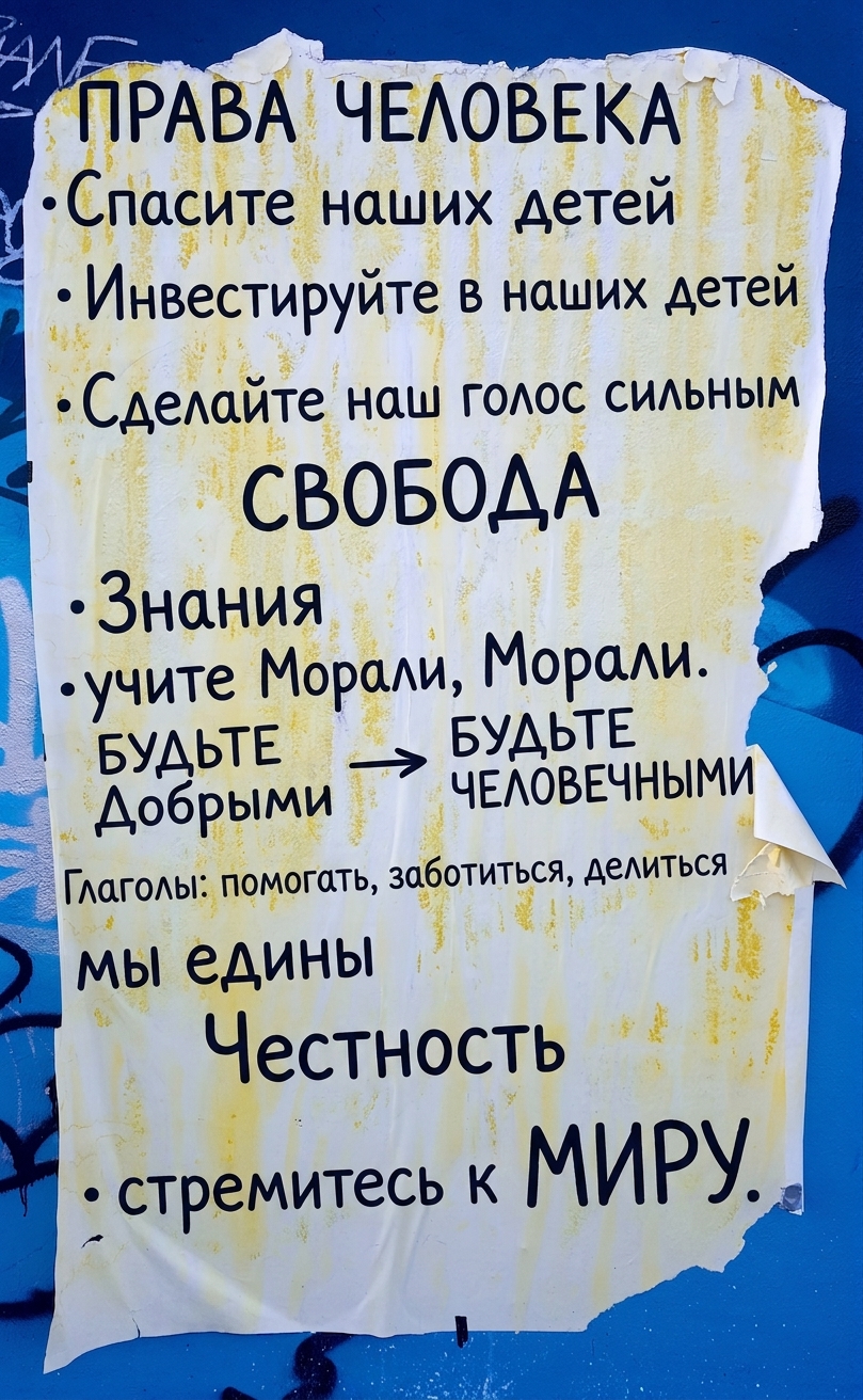 Фото порванного плаката с этическими декларациями на стене.