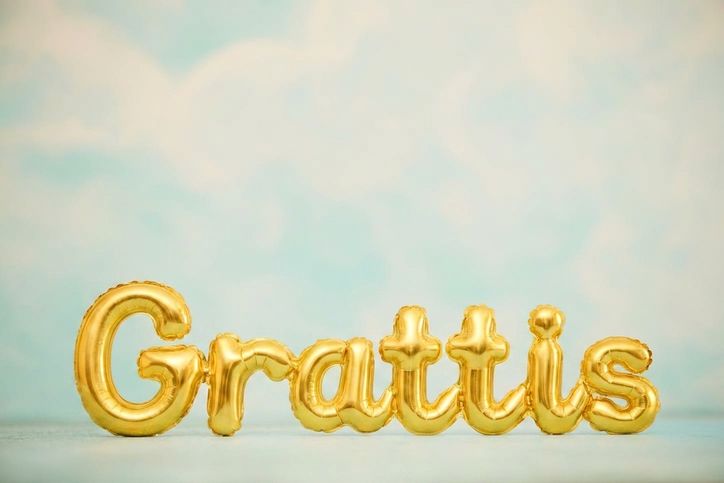 guldballonger mot blå himmel med texten grattis