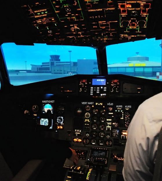 Foto av cockpit i ett flygplan med skymd pilot