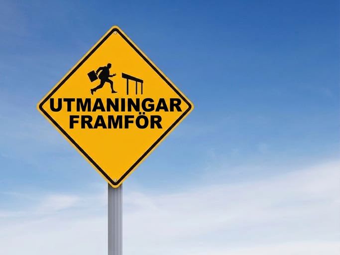 Vägmärke med en man som hoppar ett hinder och texten "Challenges Ahead"