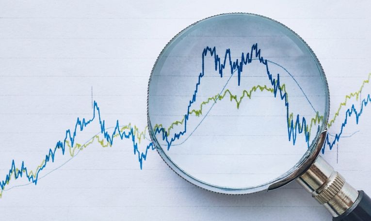 แว่นขยายบนตัวเลขในกราฟ แสดงถึงการตรวจสอบทางการเงิน