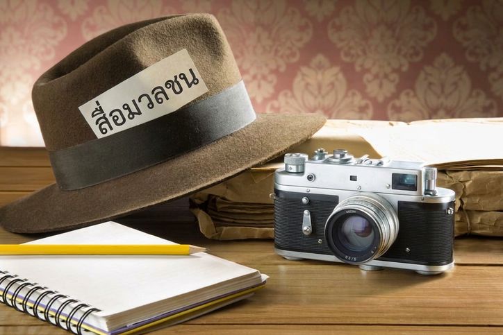 ภาพกล้องถ่ายรูป สมุดโน้ต และหมวกติดป้ายสื่อมวลชน