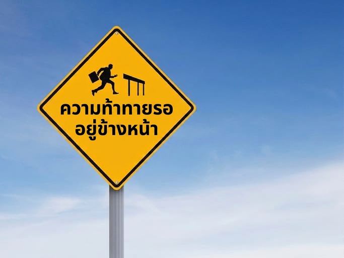 ป้ายจราจรแสดงภาพคนกระโดดข้ามรั้ว พร้อมข้อความ "Challenges Ahead"