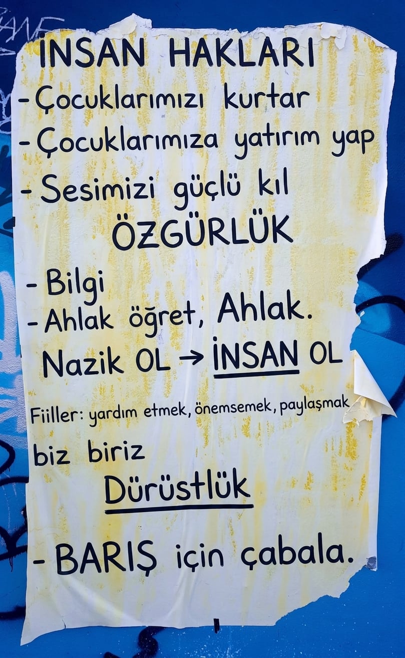 Duvarda etik bildirgelerin yer aldığı yırtık bir posterin fotoğrafı