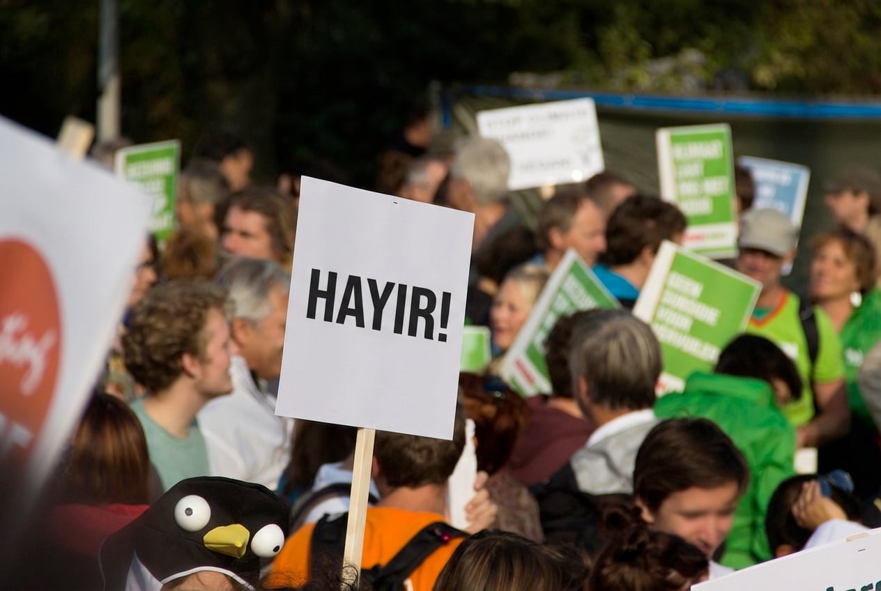 “Hayır!” yazan bir pankart tutan protestocunun yer aldığı protesto