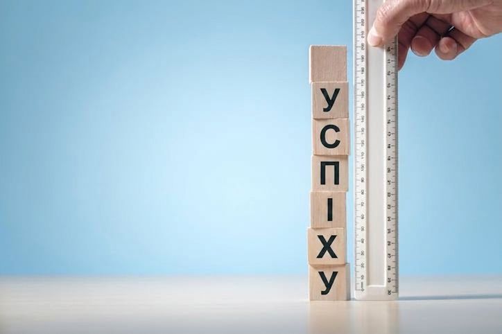 Лінійка біля кубиків зі словом success як метафора вимірювання прогресу