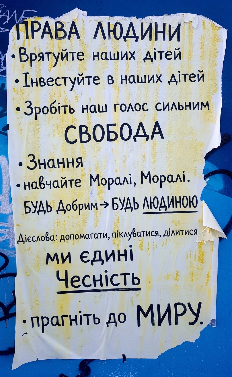 Фото порваного плаката на стіні з етичними деклараціями.