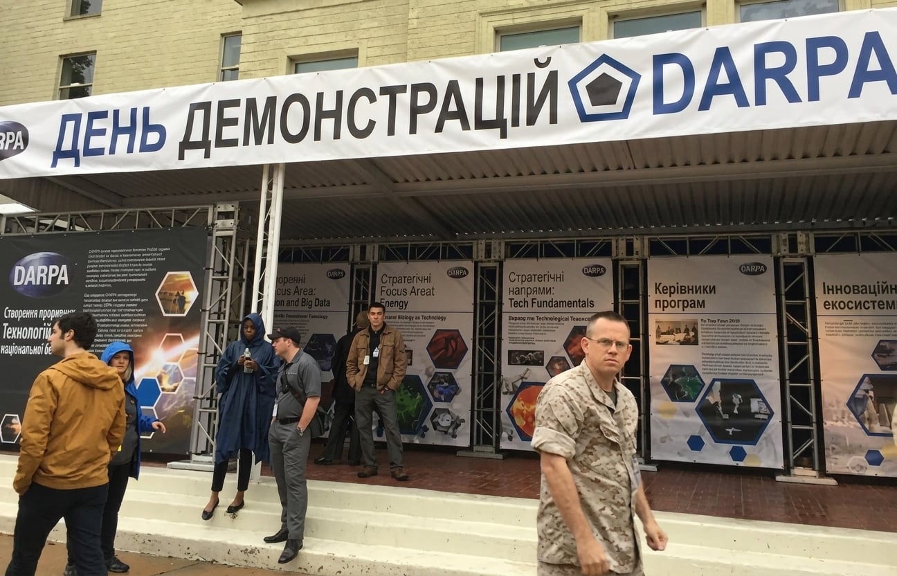 Знімок виставкових стендів на конференції з банером «DARPA Demo Day»