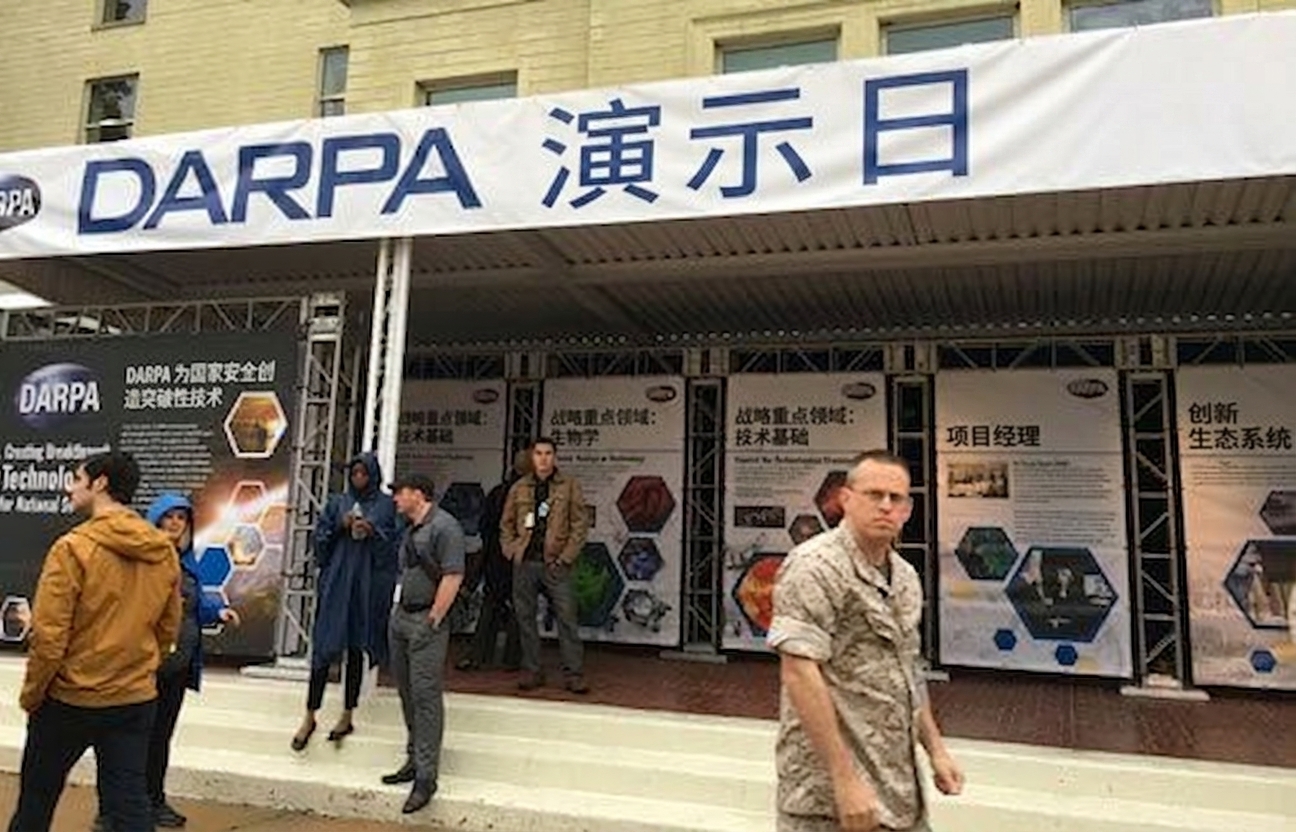 会议展区图片，横幅写有"DARPA Demo Day"