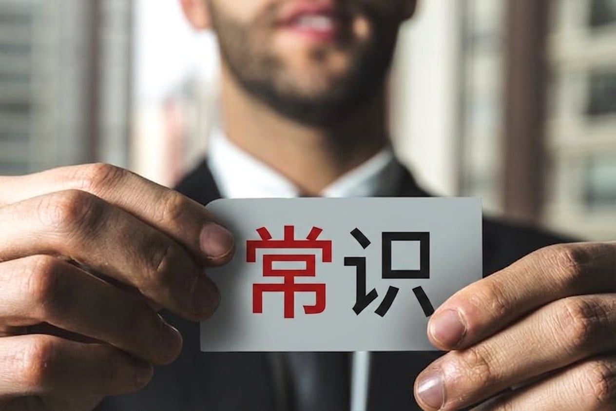 一名男子举着写有"常识"的标签