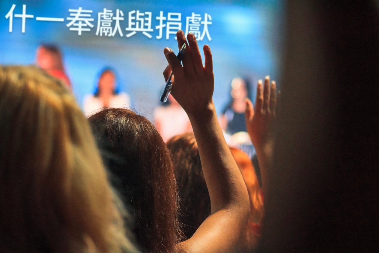 觀眾中一人舉手向台上座談者發問的照片