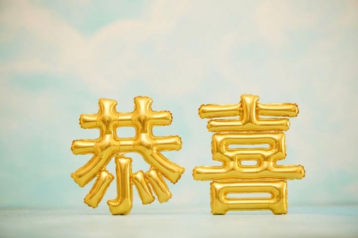 藍天前的金色氣球拼成 congrats
