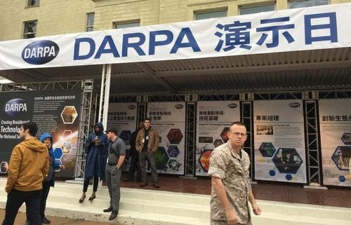 會展攤位，上方橫幅為「DARPA Demo Day」