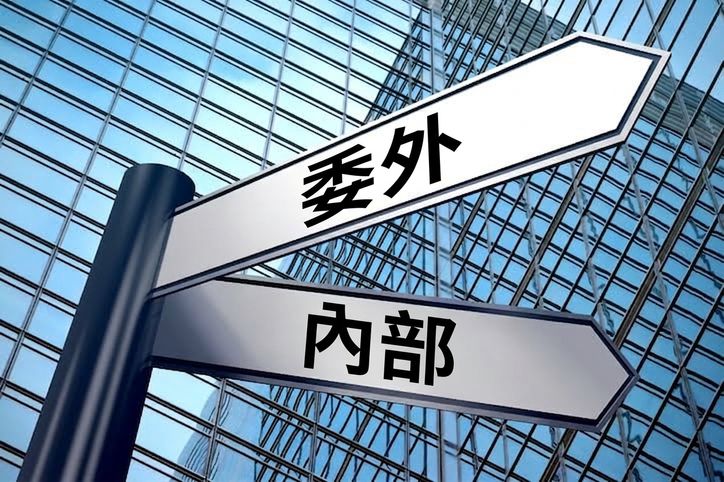指示牌顯示兩個方向：外包或自建