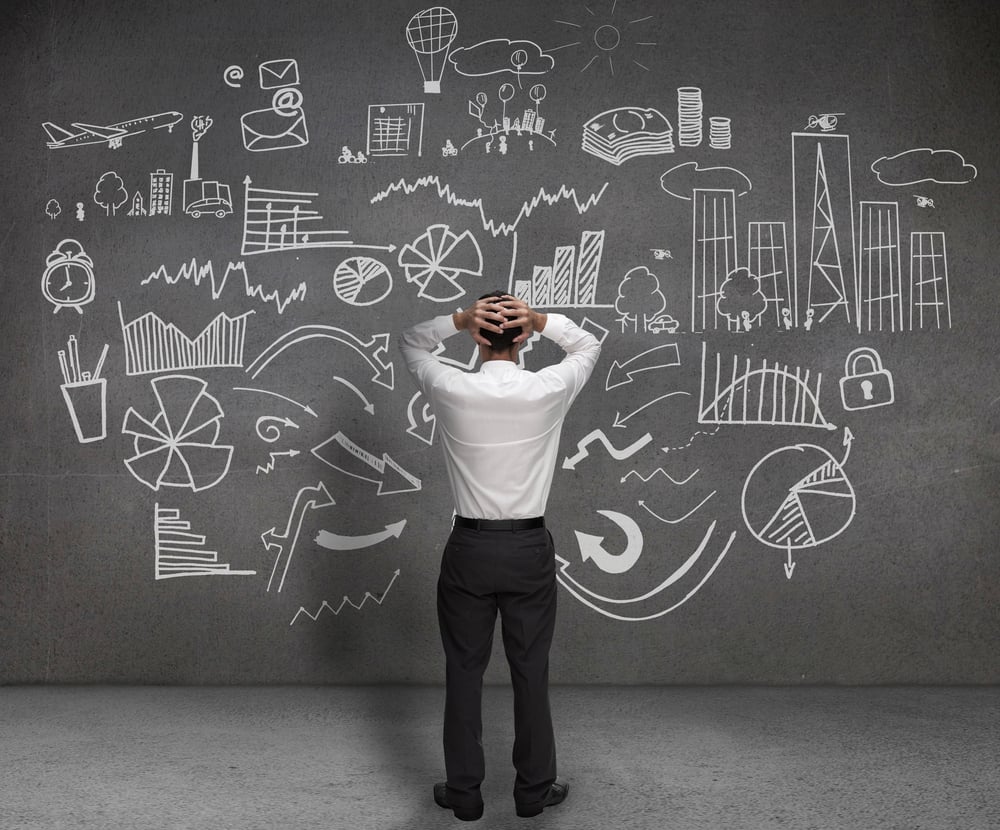 Overwhelmed man staring at busy blackboard