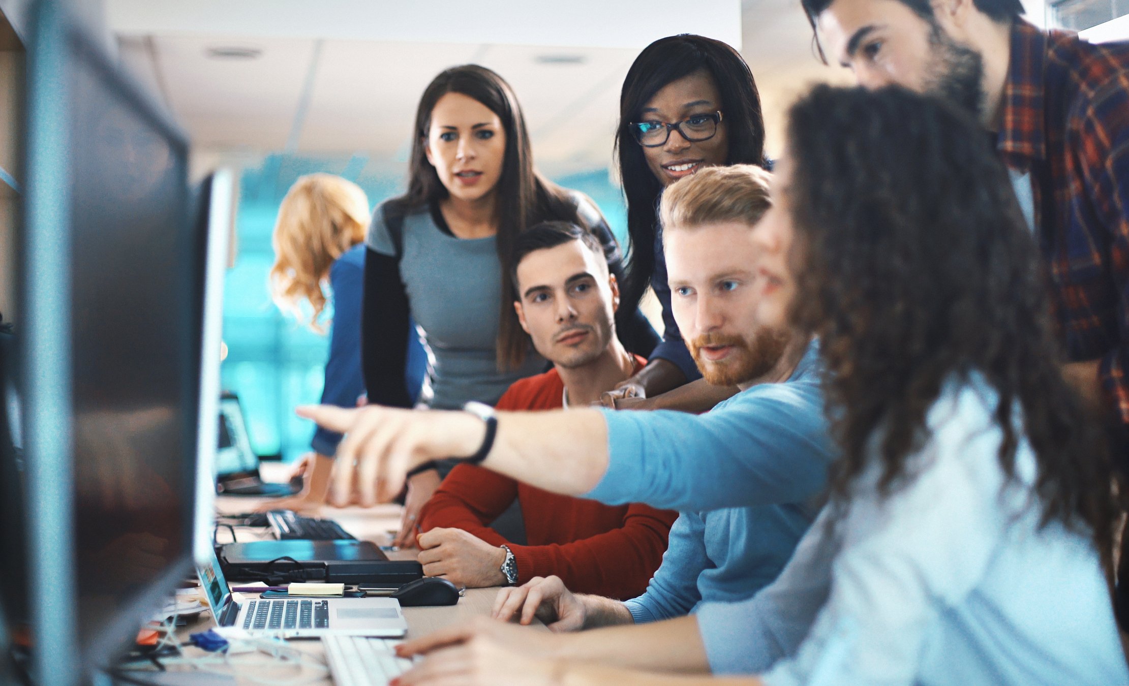 People collaborating in front of a computer