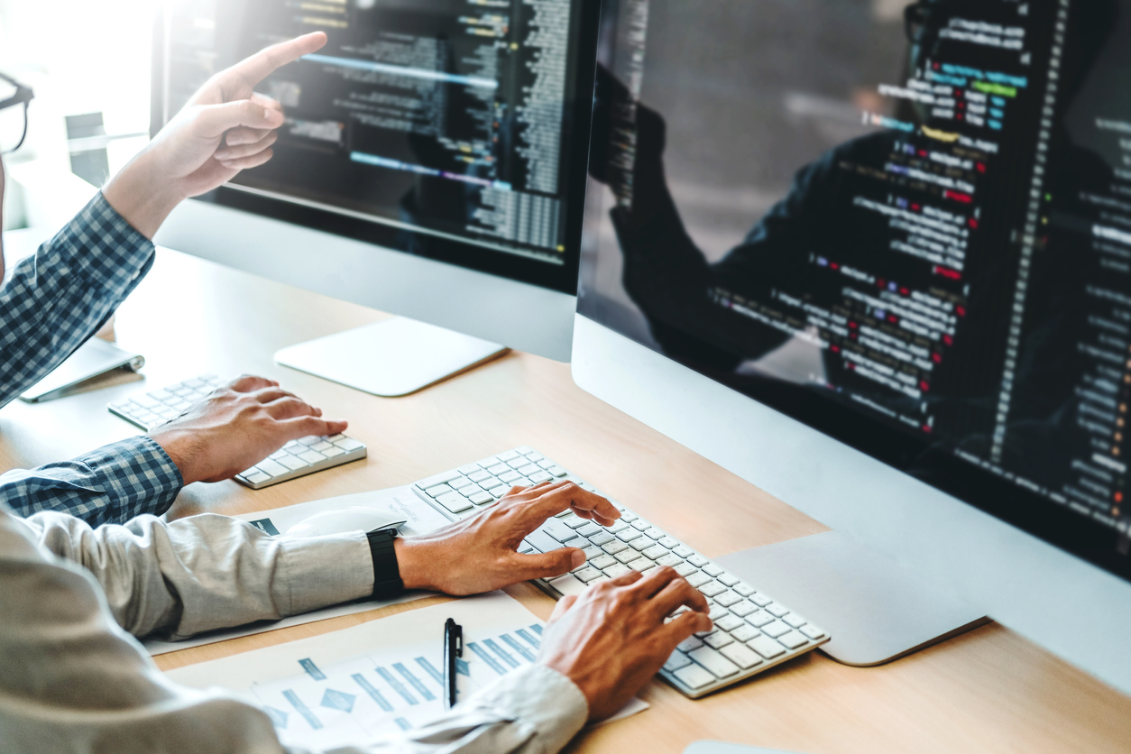 Two programmers working together improving software code