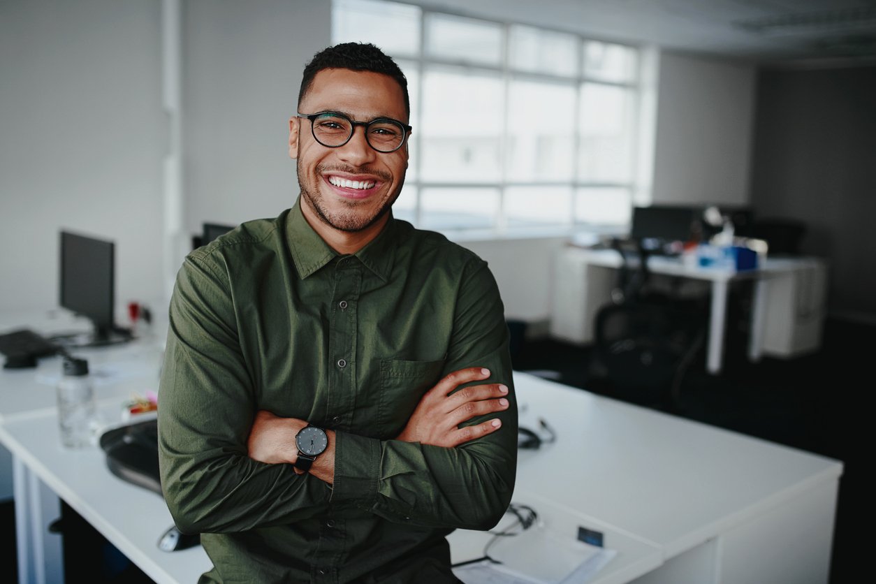 Portrait of a happy confident young african american professional standing with his arms crossed looking at camera