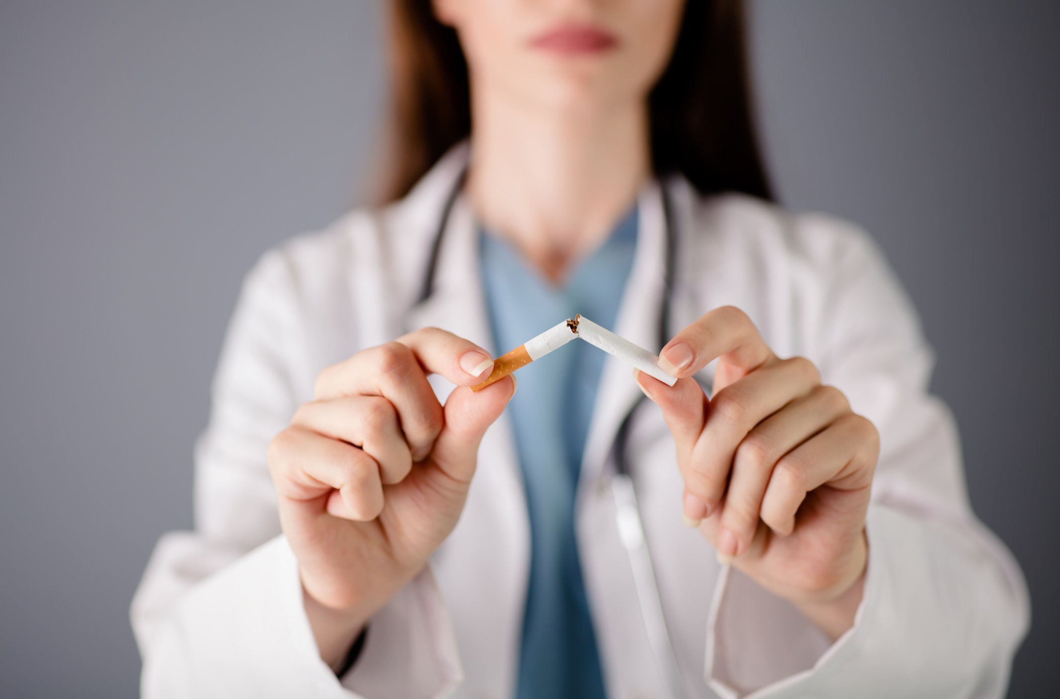 A doctor holding a broken cigarette.