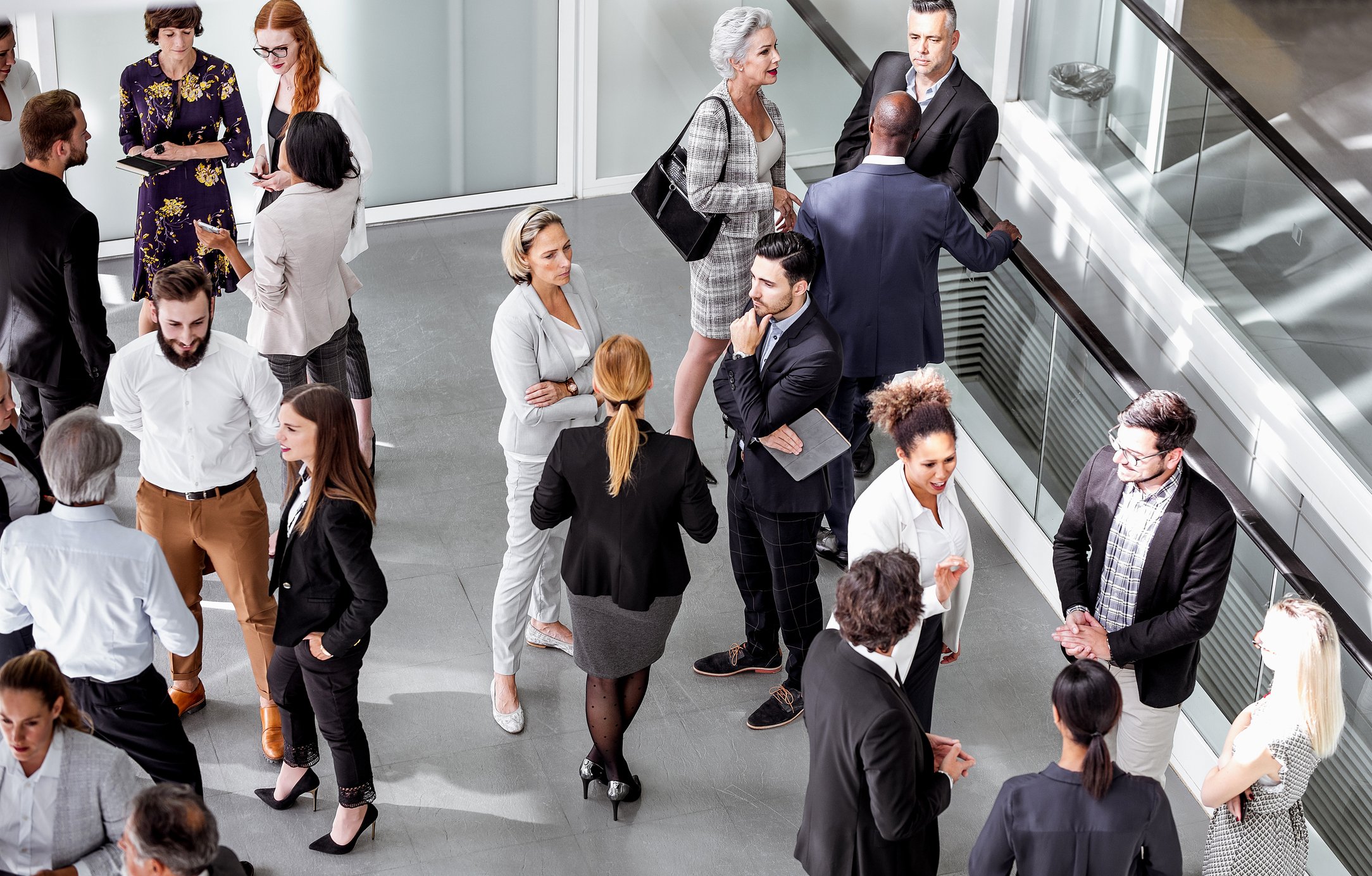 A group of business people standing around and talking.