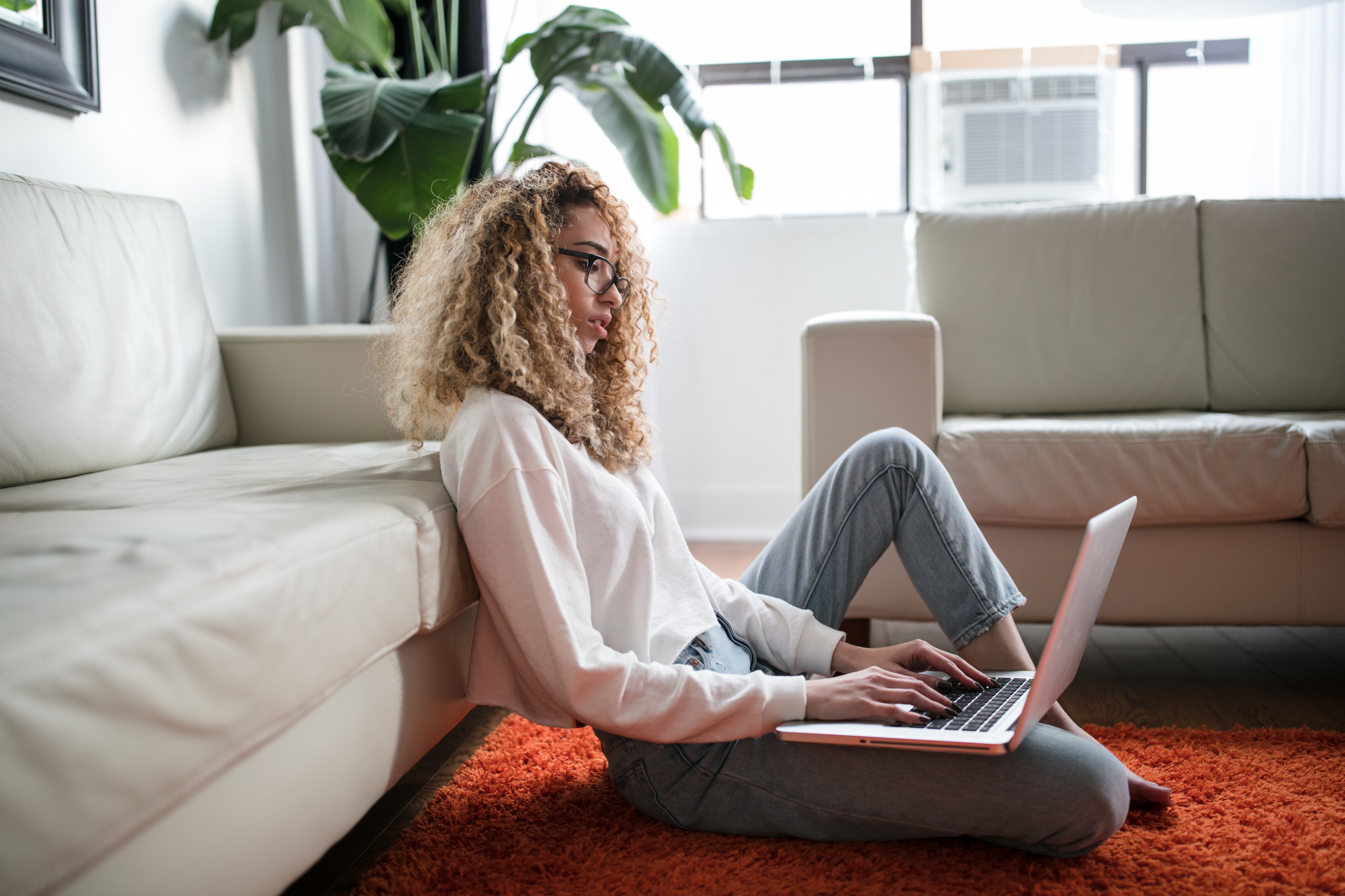 Woman working on her laptop from the floor