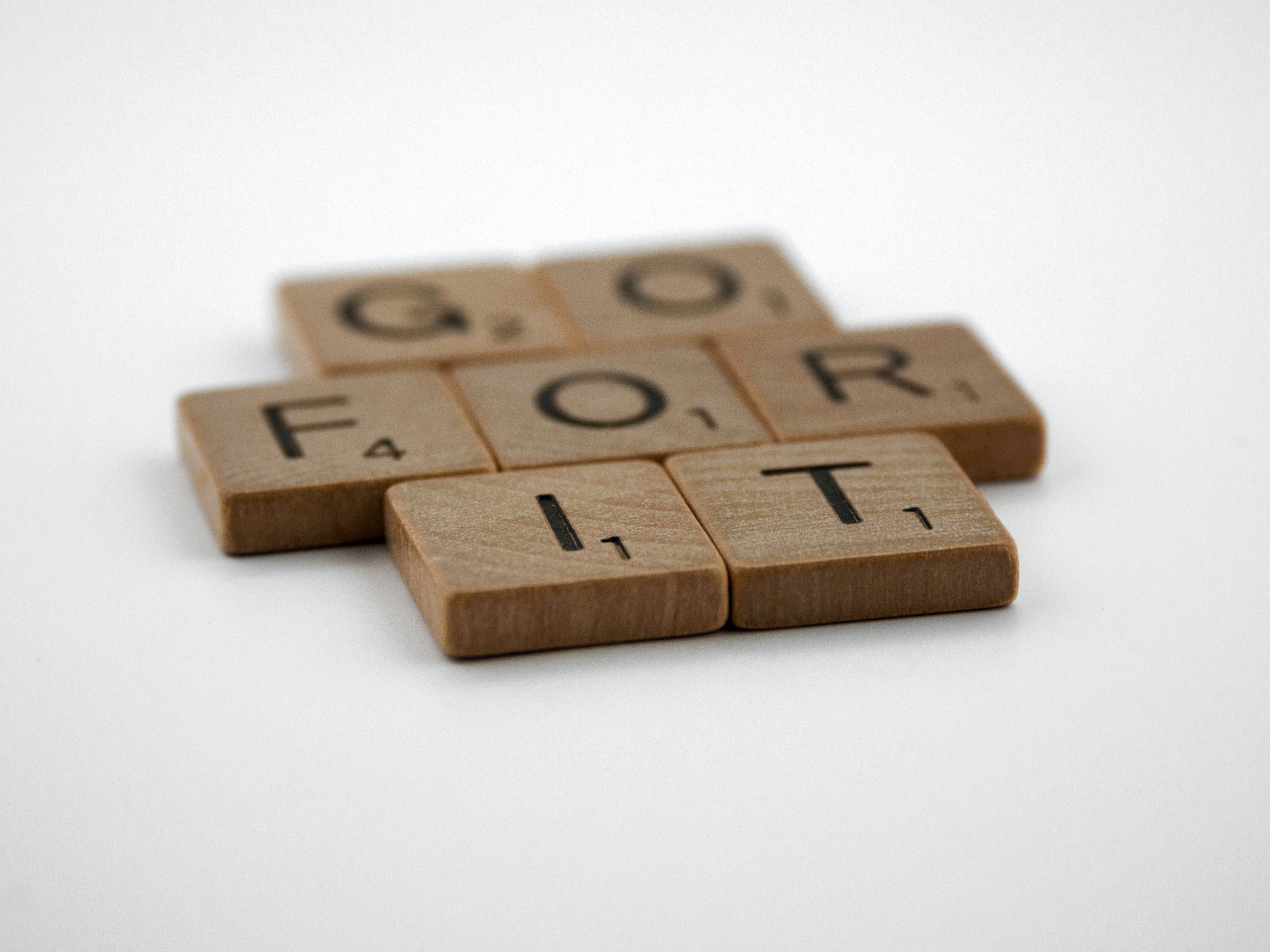 Scrabble letter tiles spell out the phrase Go For It