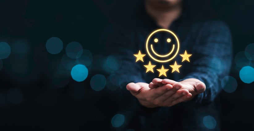 Hands holding a smiley face surrounded by five stars to indicate a very satisfied customer