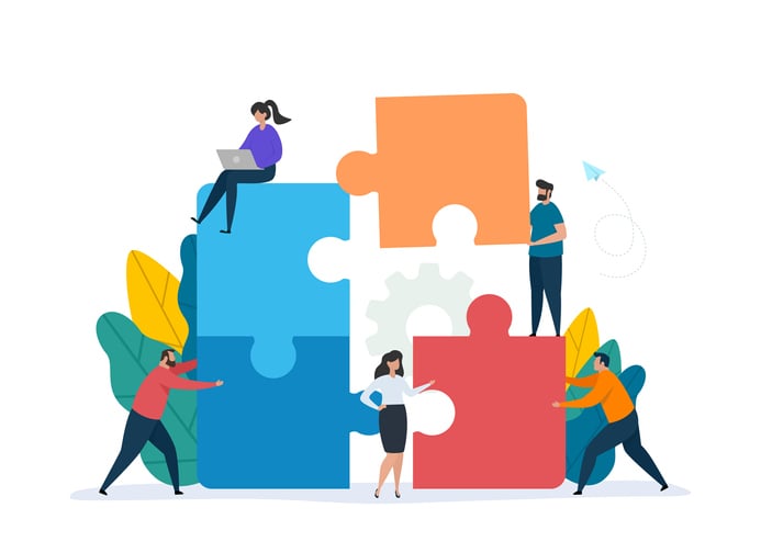 Teamwork concept showing people putting together a giant puzzle