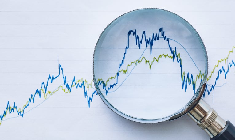 A magnifying glass over chart figures to represent financial review