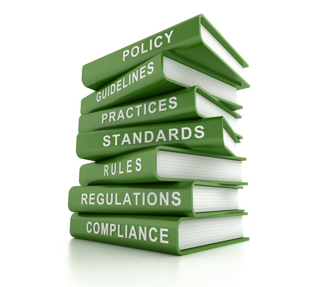 A stack of green books including ones that say policy and standards